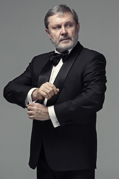 Middle aged male adult wearing a suit isolated on gray