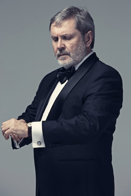 Middle aged male adult wearing a suit isolated on gray