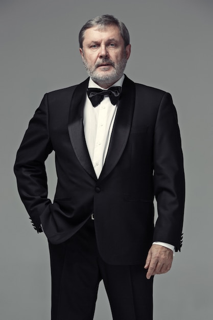 Free photo middle aged male adult wearing a suit isolated on gray