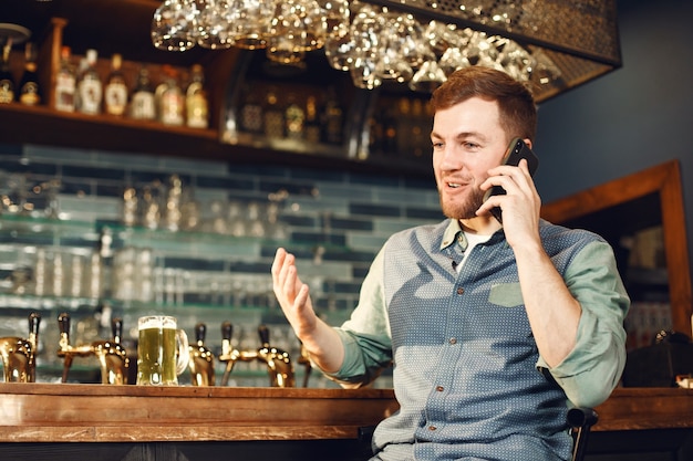 Middle-aged man. Guy with a phone at bar. Man in a denim shirt in a cell.