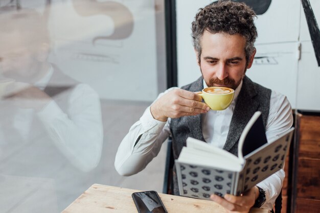Middle aged man jewish nationality spends afternoon or morning in trendy or hipster coffee shop