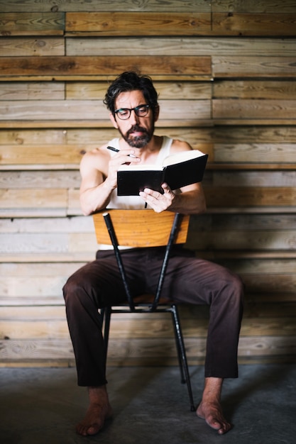 Free photo middle-aged man writing in book