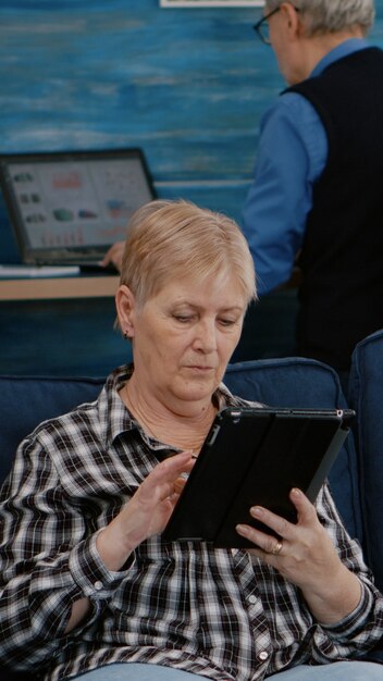 전자 책을 읽고 태블릿을 들고 편안한 중년 할머니