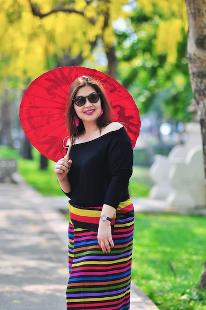 Middle aged Thai lady in colorful northern Thai style costume at outdoor tourist place in Chiang Mai Lanna Thailand