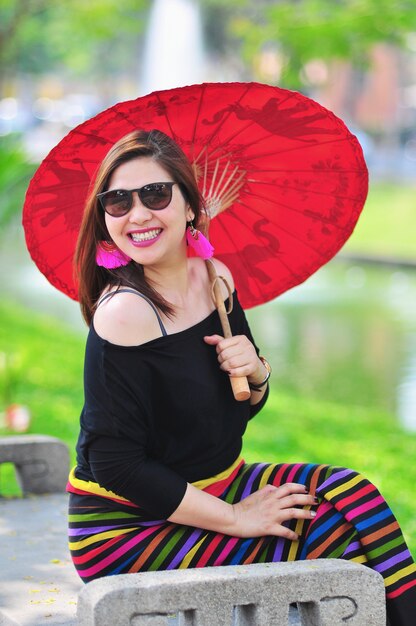 Тайская леди среднего возраста в ярких костюмах в северном тайском стиле на открытом туристическом месте в Чианг Май Ланна, Таиланд