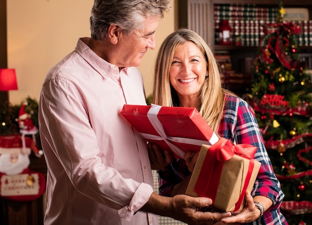 Middle aged woman giving a present to a man