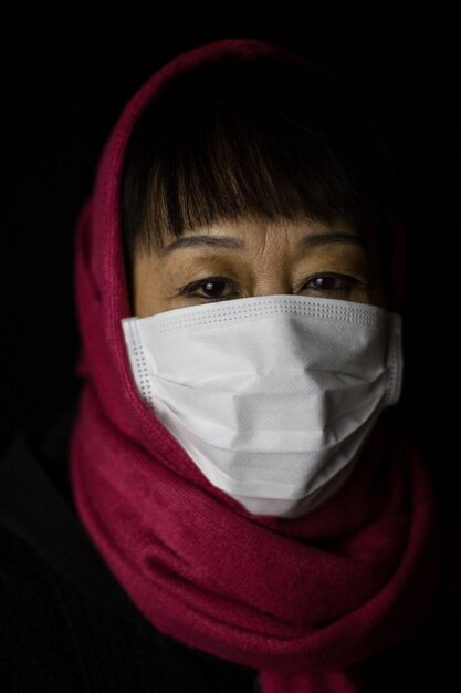 Middle-aged woman with a maroon hijab wearing a face mask