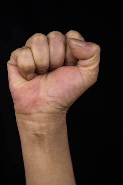 女性のエンパワーメントと権利を示す彼女の拳を示す腕を伸ばした中年の女性