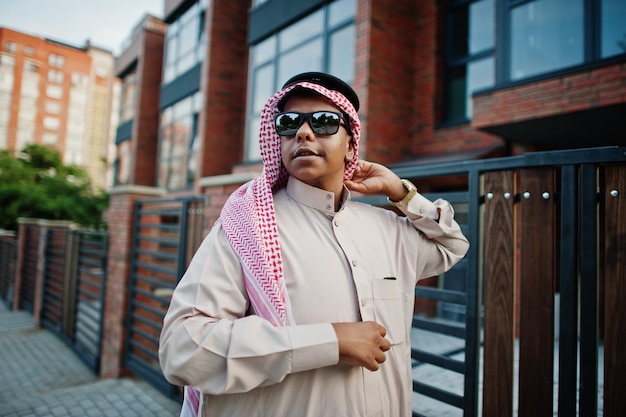 Free photo middle eastern arab business man posed on street against modern building with sunglasses