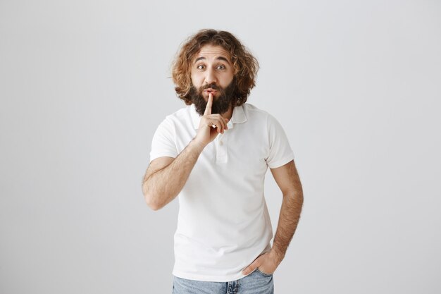 Middle-eastern bearded man shushing, asking keep secret or stay quiet