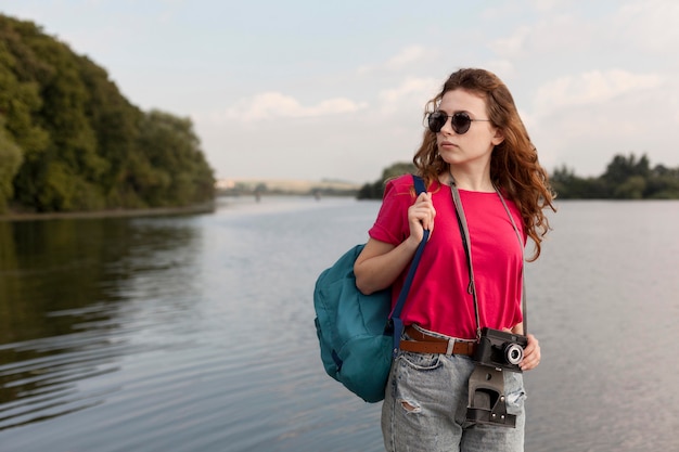Средний снимок женщины, позирующей перед озером