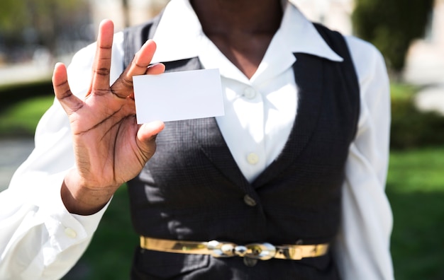 Midsection of a businesswoman showing white visiting card