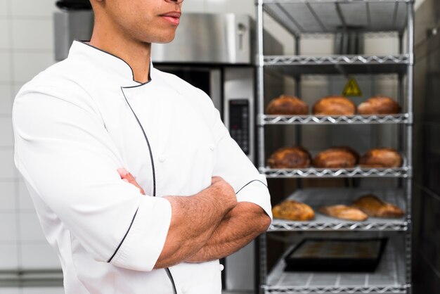 Midsection of a male baker with his arms crossed