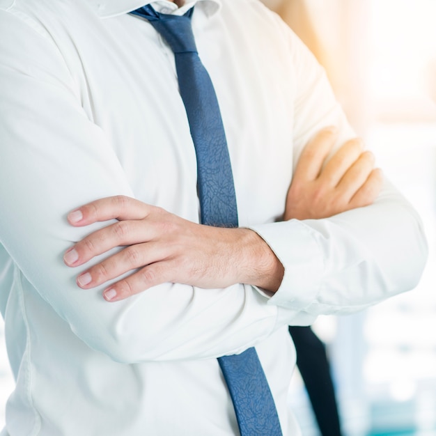 Midsection view of a businessman's folded arms