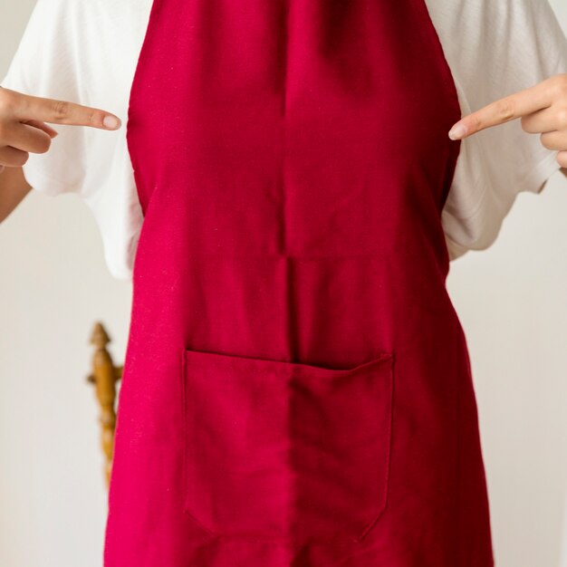 Midsection view of a woman pointing finger at red apron