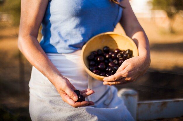 Midsection of woman holding bowl of berries