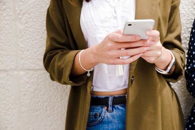 Midsection of a woman using mobile phone