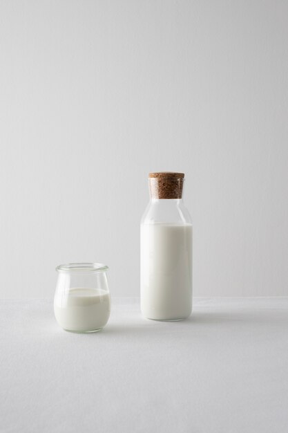 Milk bottle and glass arrangement with white background