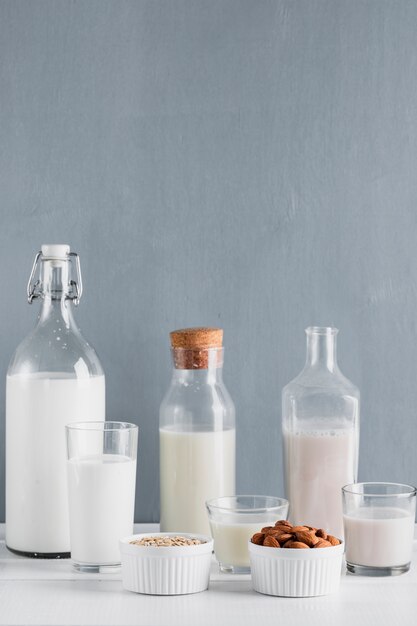 Milk in bottles and glasses with oats and almonds