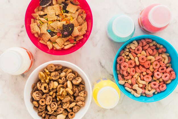 Milk bottles standing with bowls of cereal on table