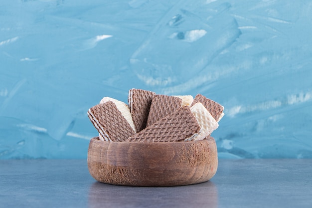 Milk and chocolate wafers in a bowl on the marble surface