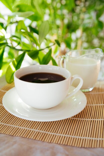 Milk and coffee cup on bamboo mat