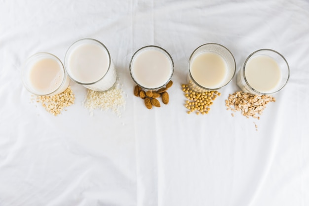 Latte in diversi tipi di bicchieri e cereali