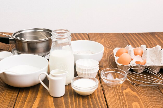 Latte; uovo; e utensili da cucina sul bancone della cucina