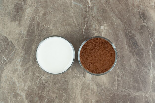 Free photo milk and ground coffee on marble table