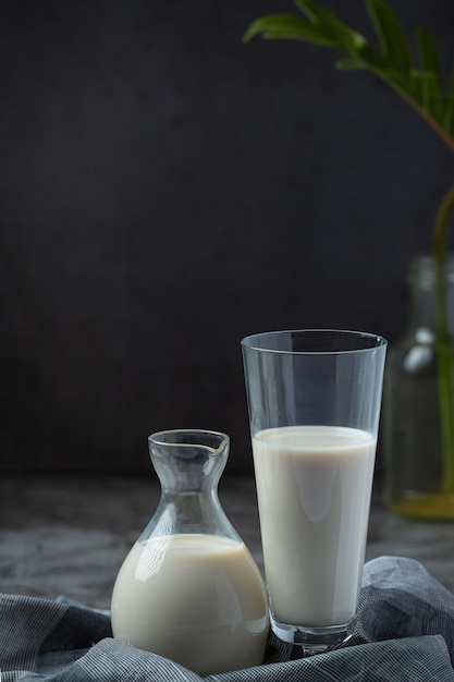 Free photo milk products tasty healthy dairy products on a table on sour cream in a bowl, cottage cheese bowl, cream in a a bank and milk jar, glass bottle and in a glass.