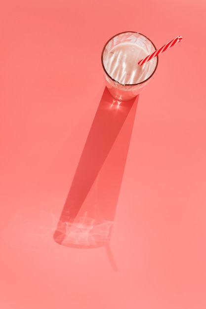 Молочный коктейль в стакане с соломой