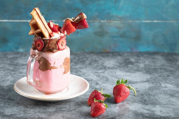 Milky cocktail jar with strawberries and waffles