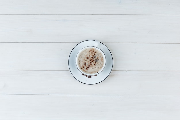 Milky coffee in a cup on a wooden background. top view.