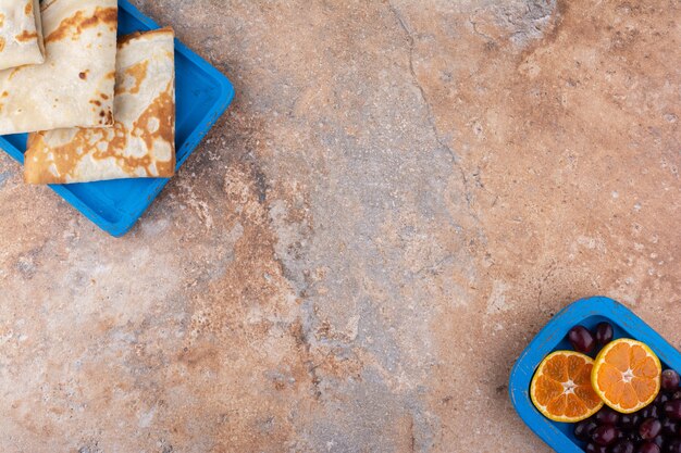 Milky crepes with berries and orange slices