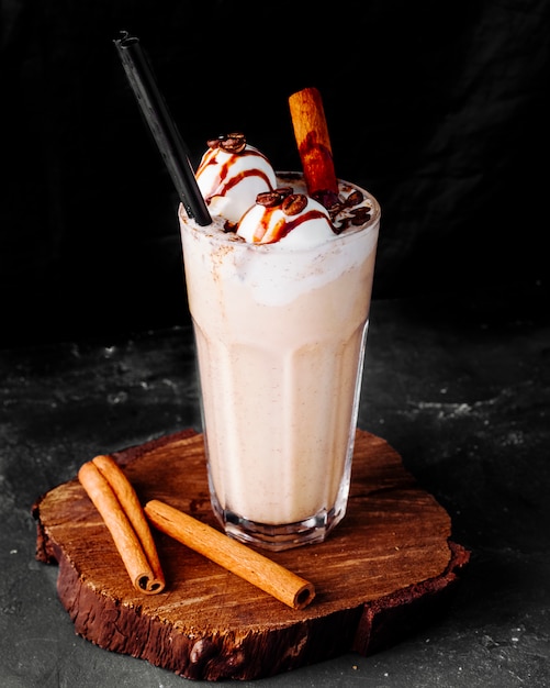 Milky smoothie with icecream balls and cinnamon sticks.