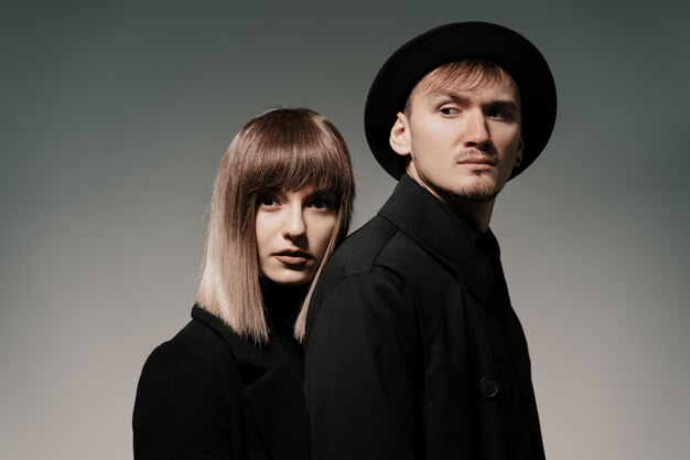 Millennial fashion couple on a gray in studio