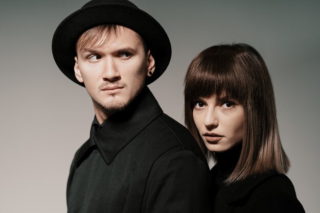 Millennial fashion couple on a gray in studio