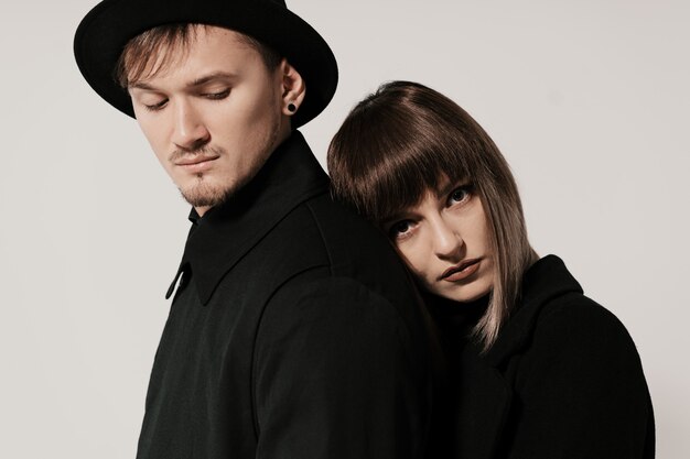 Millennial fashion couple on a white gray in studio