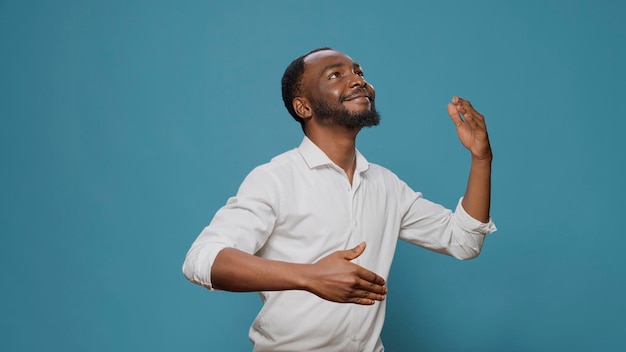 Millennial person doing robotic dance moves on camera, having fun with contemporary disco celebration. Young carefree man moving as robot, dancing on unique urban music. Holiday party.