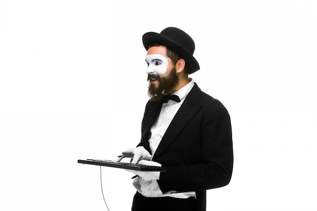 Mime as a businessman holdinga keyboard