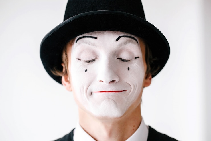 Free Photo mime in black hat stands with closed eyes