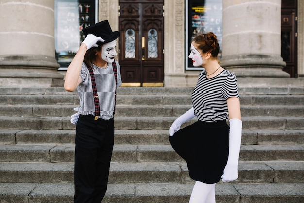 Mime couple looking at each other in front of stairway