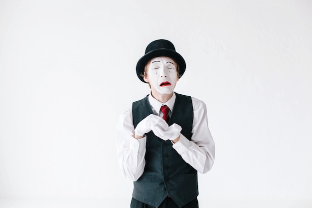 Mime cries holding his hands in white gloves together