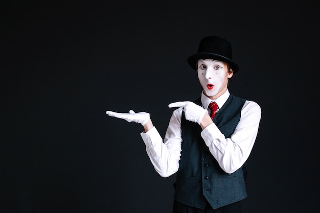 Free photo mime shows at something invisible on his palm