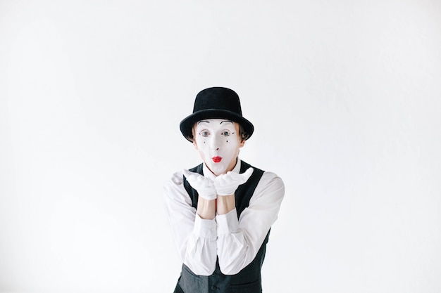 Mime with red lips sends an air kiss