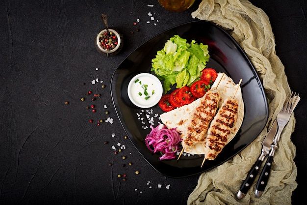 Foto gratuita kula macinata di kebab alla griglia (pollo) con verdure fresche. vista dall'alto