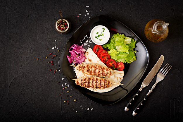 Minced Lula kebab grilled turkey (chicken) with fresh vegetables. Top view