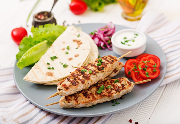 Minced Lula kebab grilled turkey (chicken) with fresh vegetables.