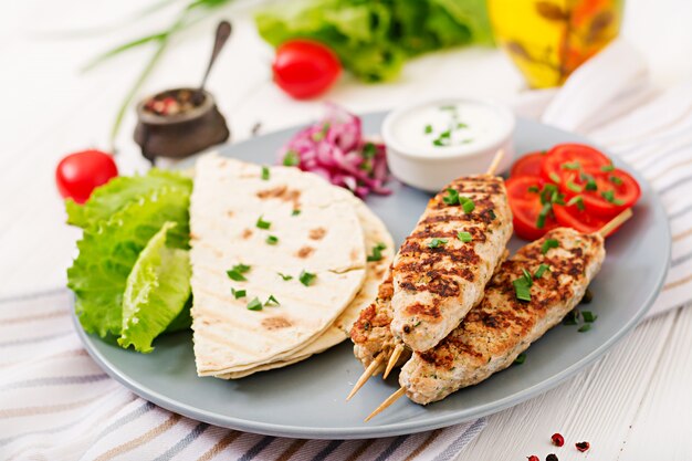 Minced Lula kebab grilled turkey (chicken) with fresh vegetables.