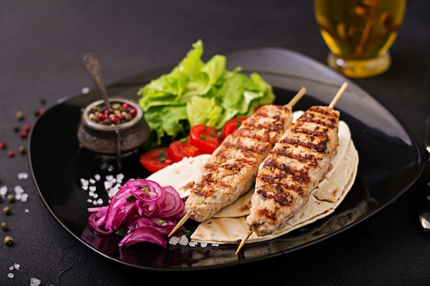 Minced Lula kebab grilled turkey (chicken) with fresh vegetables.